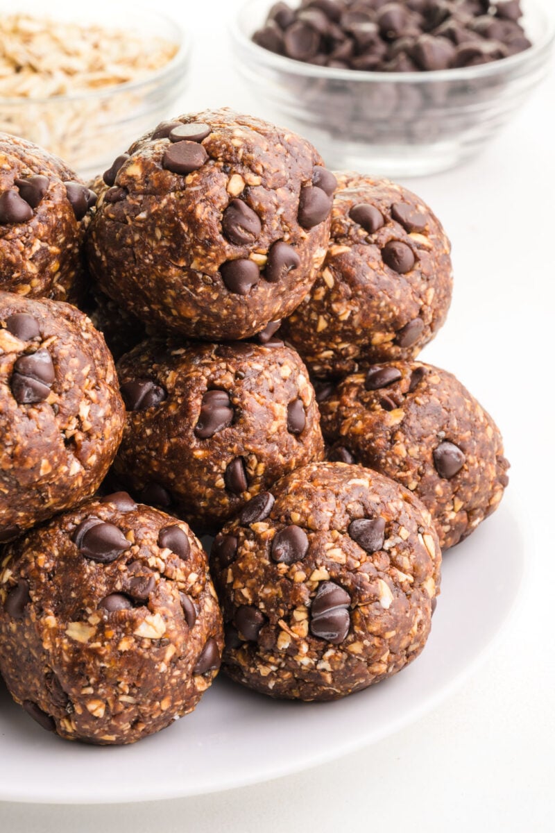 A stack of chocolate energy balls have chocolate chips on top.