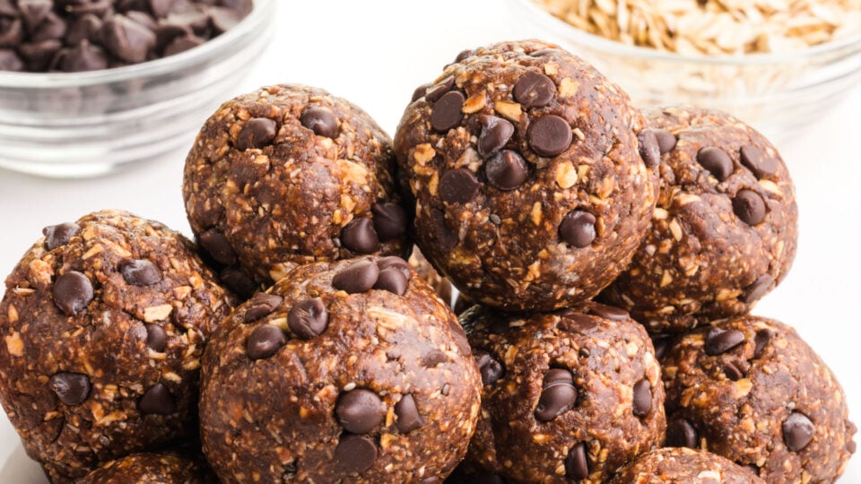 A stack of energy balls with chocolate chips in the background.