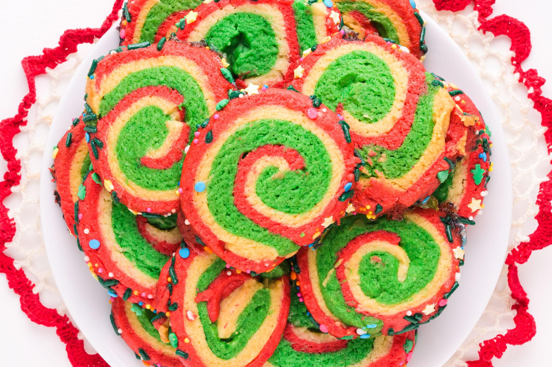 Looking down on a batch of Christmas pinwheel cookies on a plate.