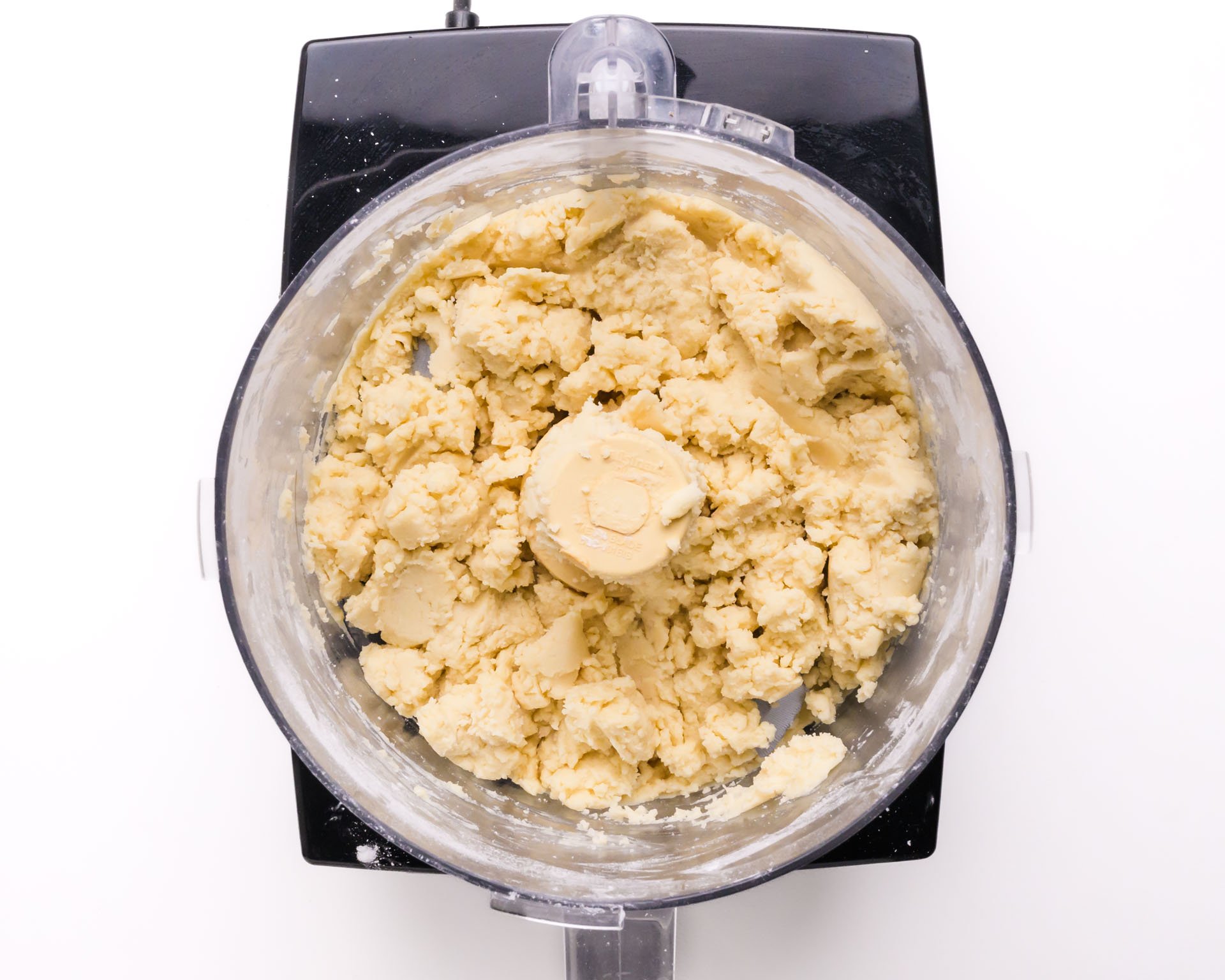 Cookie dough ingredients are in a food processor.
