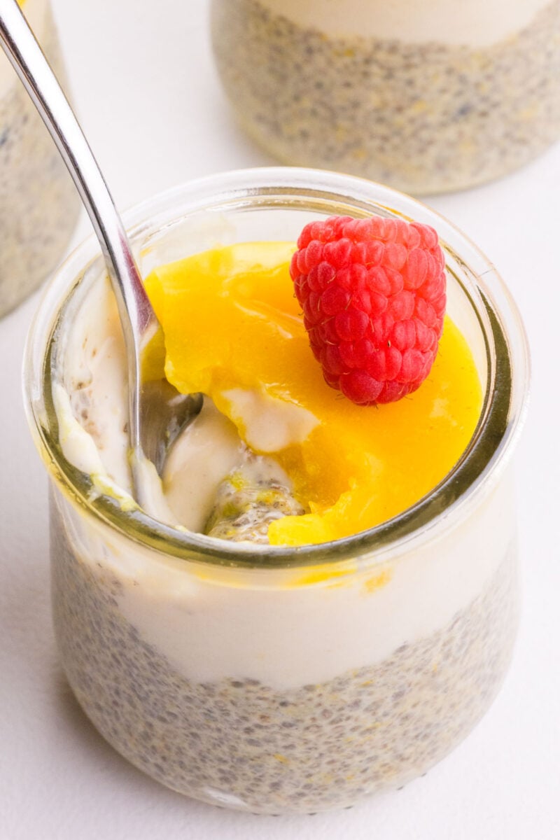 A spoon is in a serving of lemon chia pudding.