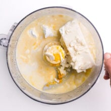 Silken tofu and other ingredients are in a food processor waiting to be blended.