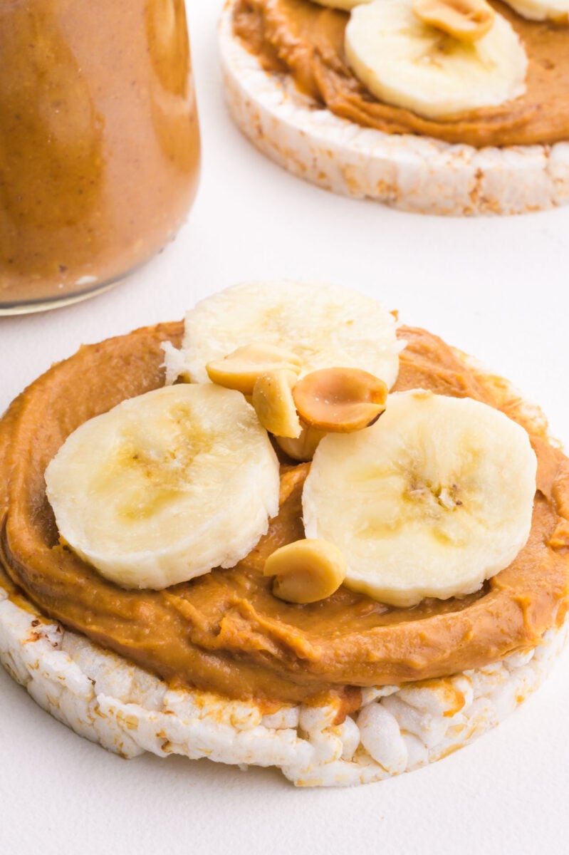 A peanut butter spread is on rice cakes with sliced bananas on top.