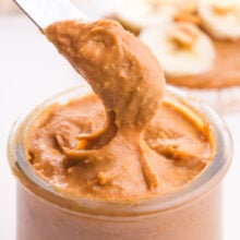 A butter knife takes a serving of peanut butter from a jar.
