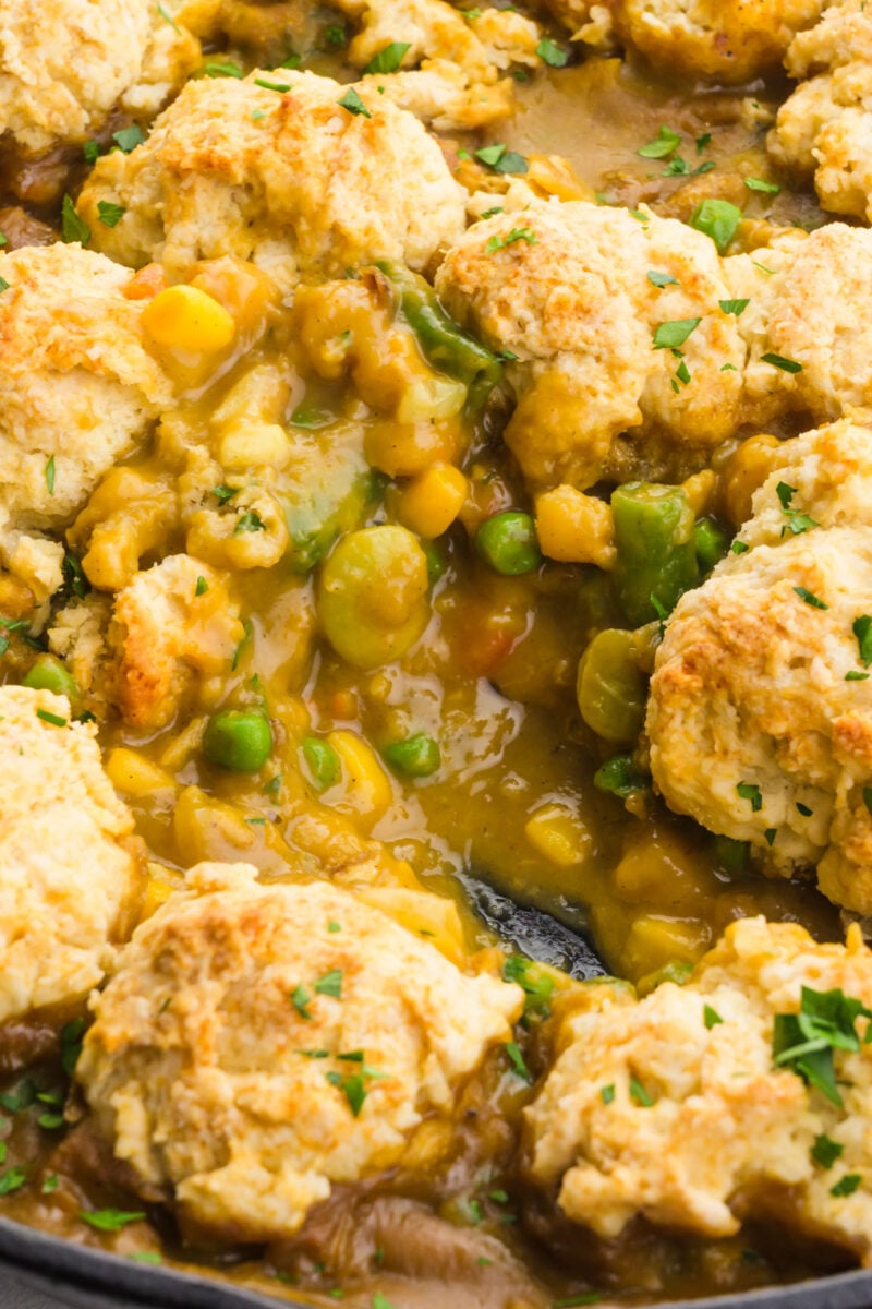 Looking into a skillet with chickpea pot pie and a portion has been removed showing creamy sauce inside.