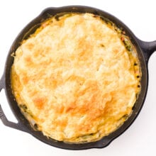 A golden pastry tops a pot pie in a black skillet.