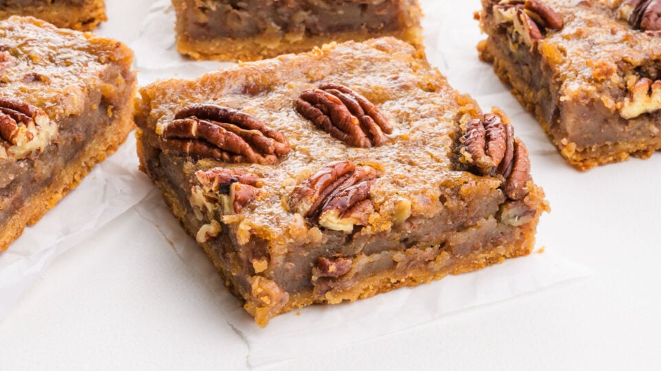 Several slices of pecan pie bars on a table.