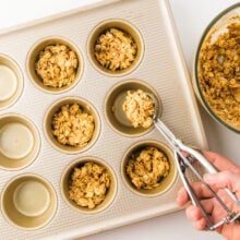 An oatmeal mixture is portioned into muffin pan compratments.