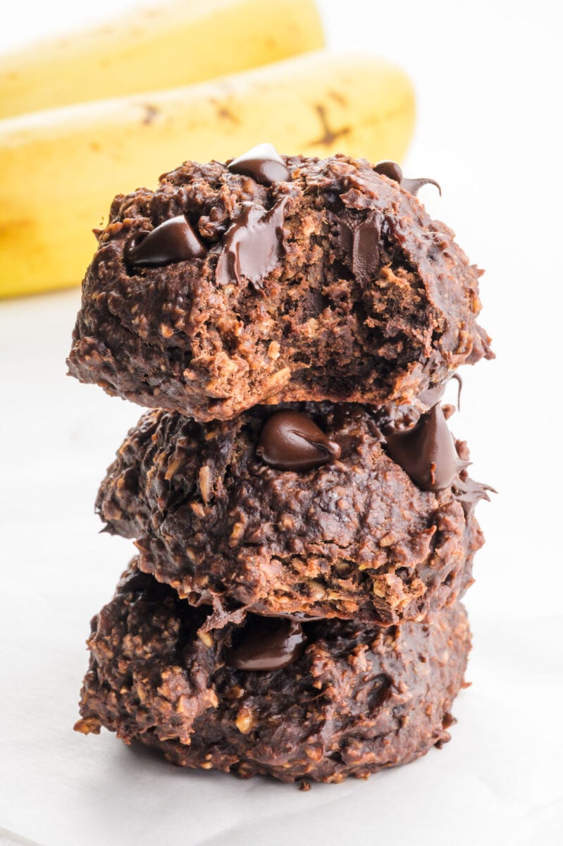 A stack of chocolate banana cookies shows the top one with a bite taken out.