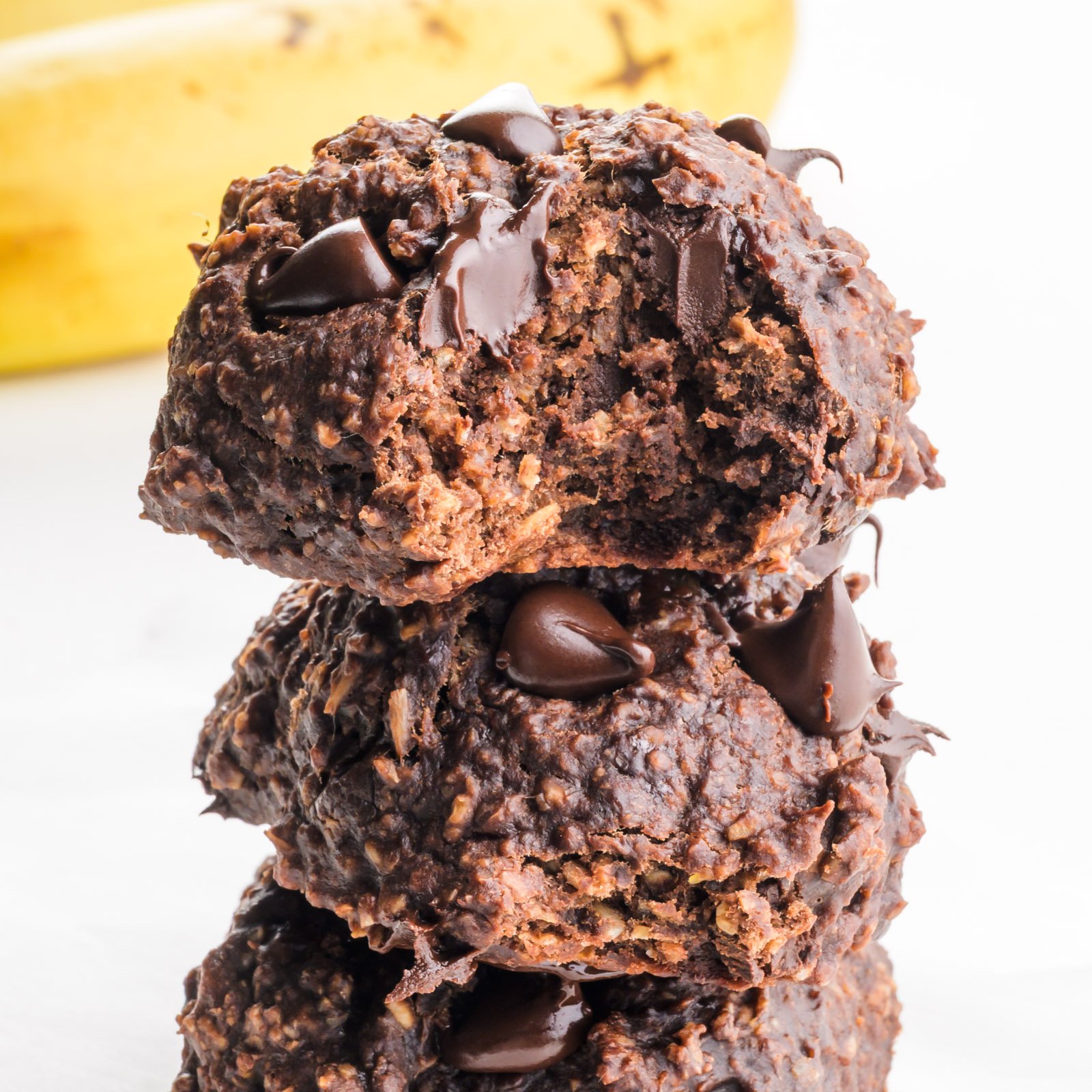 A close up of a stack of cocoa banana cookies, the top one has a bite taken out.