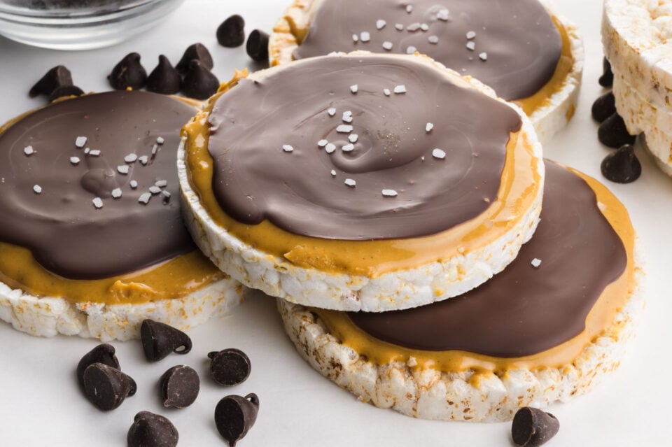 Several chocolate rice cake with peanut butter and a crackly chocolate finish topped with flaky sea salt.