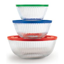 Three clear glass mixing bowls stacked, each topped with colored lids: green, blue, and red.
